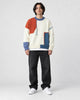 Model wearing the orange and blue cable patch sweater with jeans, front view