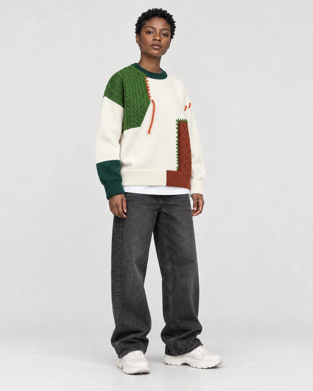 Model wearing the green cable patch sweater, three-quarter view