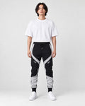 Model wearing the black color block jogger pants with gray panels and a white tee, front view