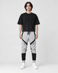 Model wearing the gray color block jogger pants with a black tee, front view