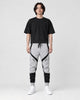 Model wearing the gray color block jogger pants with a black tee, front view