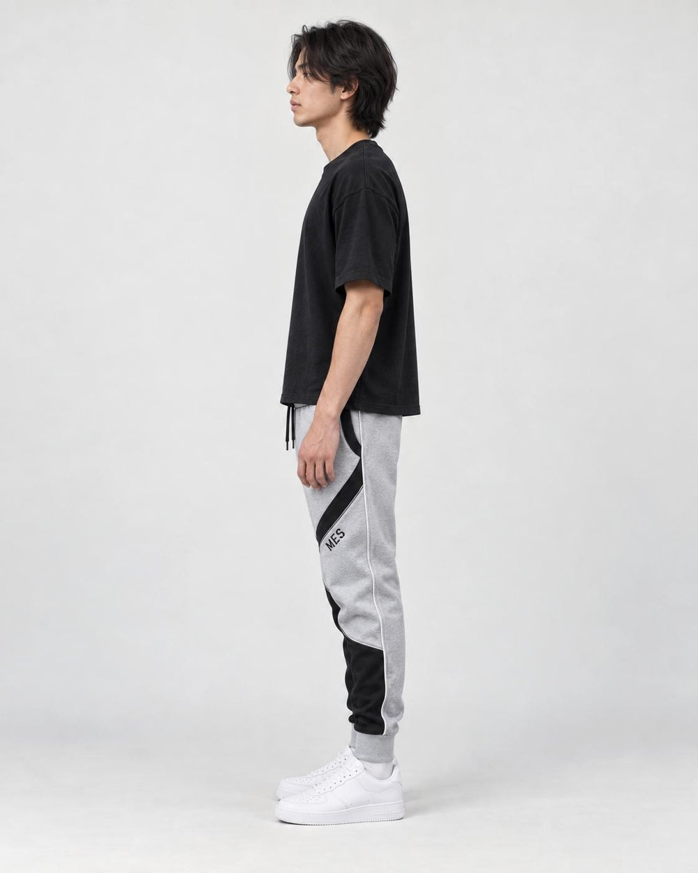 Model wearing the gray color block jogger pants, side view of the curved panels