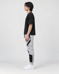 Model wearing the gray color block jogger pants, side view of the curved panels