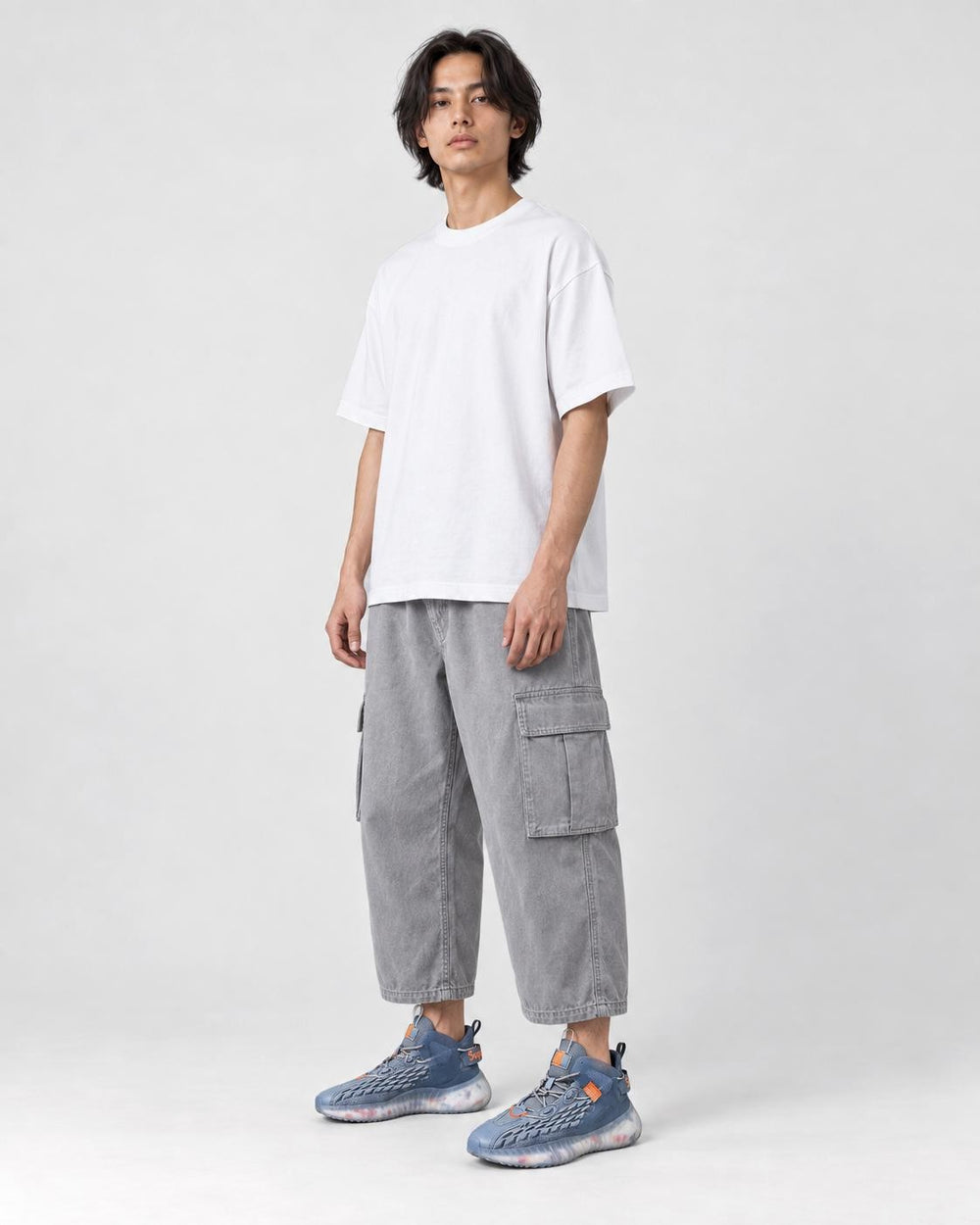 Model wearing the ice blue knit running sneakers with light gray cargo pants
