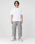 Model wearing the white knit running sneakers with light gray cargo pants, front view