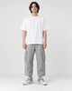 Model wearing the white knit running sneakers with light gray cargo pants, front view