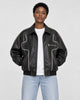 Model wearing the black PU leather zip jacket with white contour piping, front view