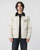 Model wearing the stone cotton chore jacket with a black corduroy collar, front view