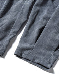 Close-up of the gathered pleated cuff on the blue gray corduroy pants