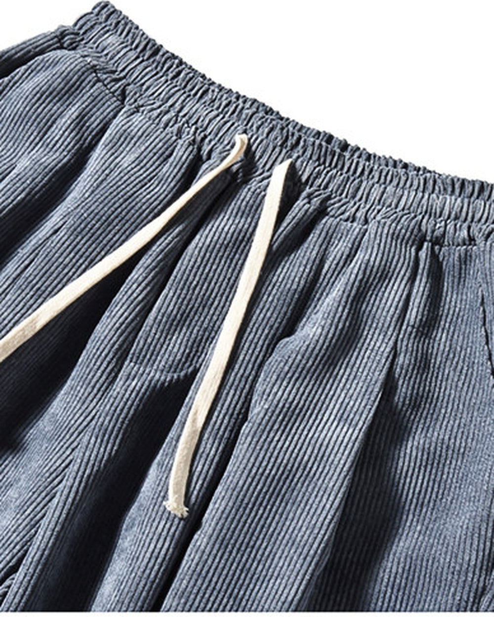 Close-up of the elastic waist, cream drawcord and pocket on the blue gray corduroy pants