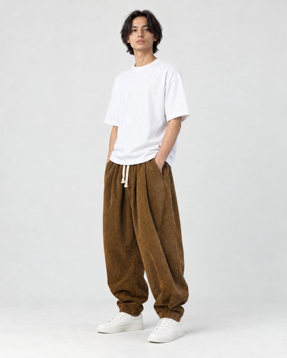 Model wearing the brown corduroy lantern pants with a white tee, three-quarter view