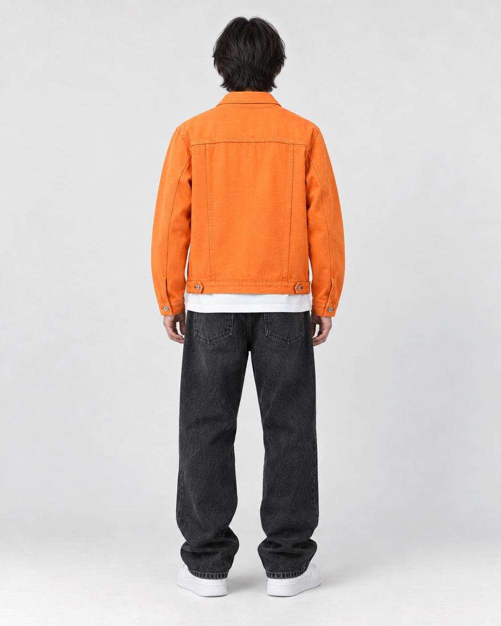Model wearing the orange denim trucker jacket, back view