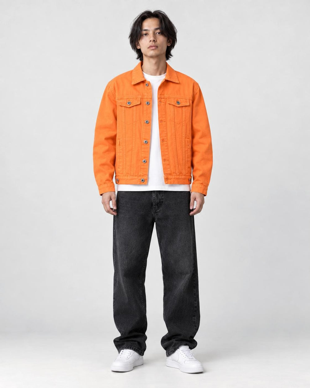 Model wearing the orange denim trucker jacket over a white tee, front view