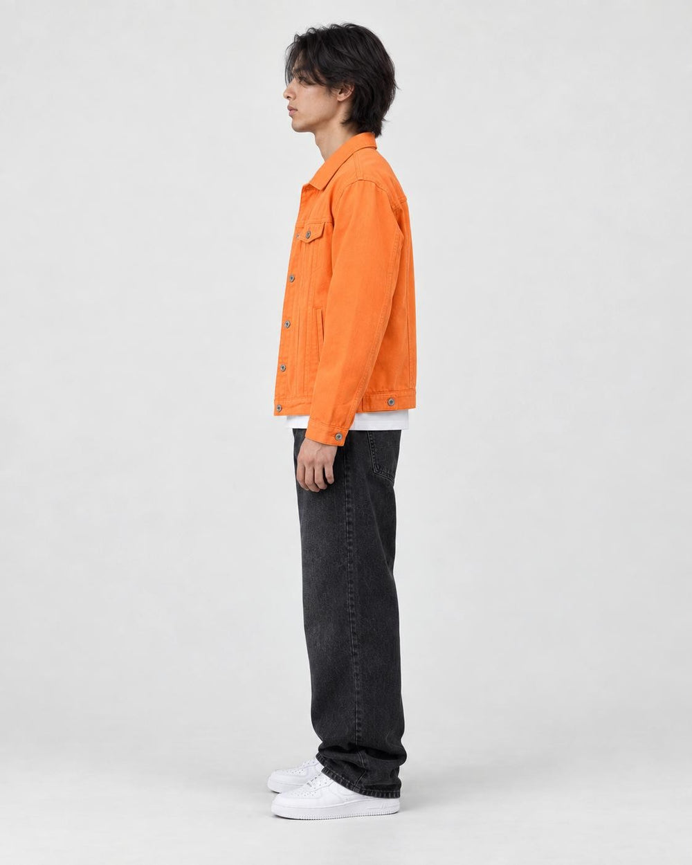 Model wearing the orange denim trucker jacket, side view