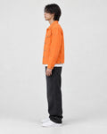 Model wearing the orange denim trucker jacket, side view