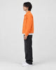 Model wearing the orange denim trucker jacket, side view