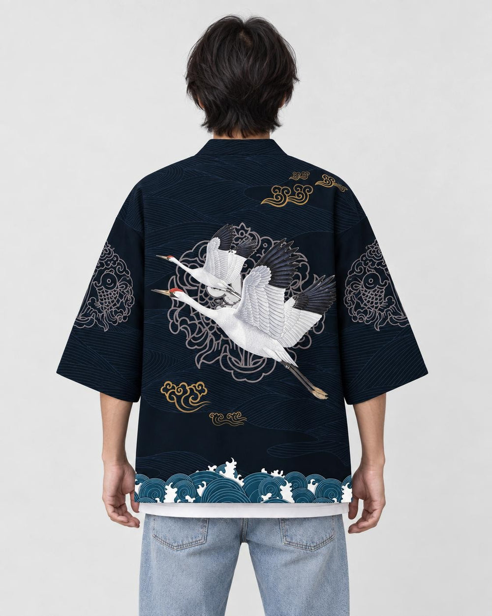 Man seen from behind in the dark navy haori with two white cranes in flight and a teal wave band, over a white tee