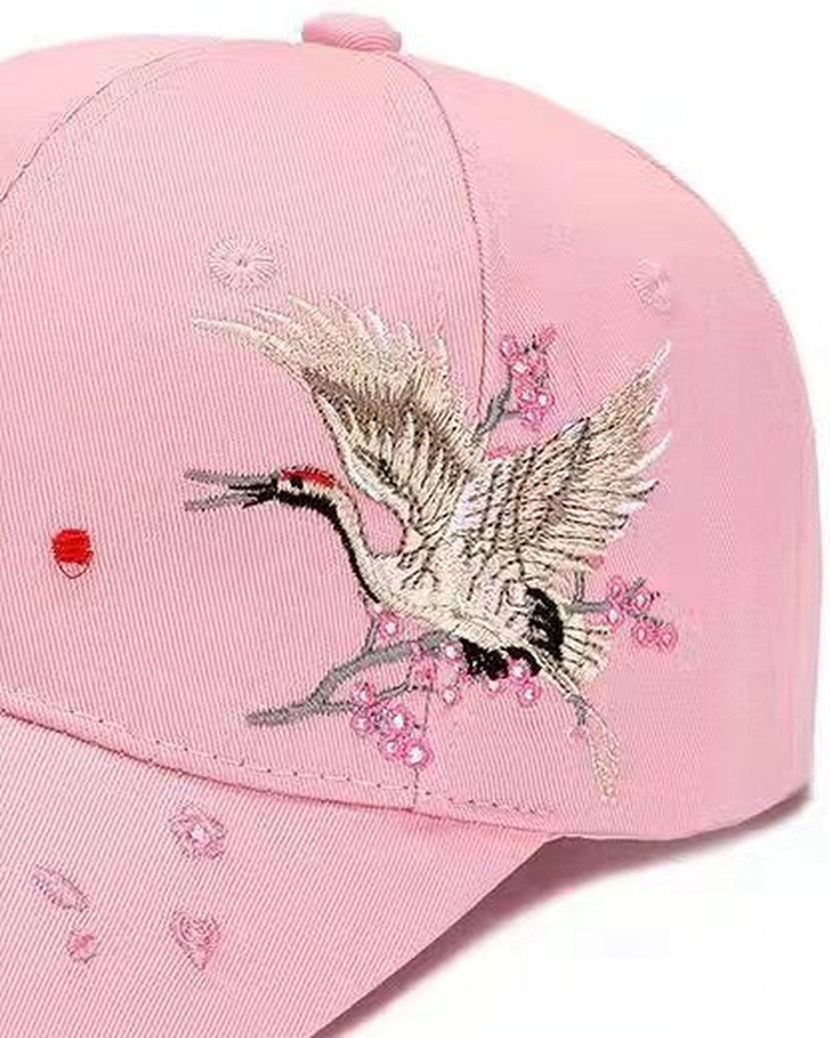 Close-up of a crane and pink blossom embroidery on the pink baseball cap