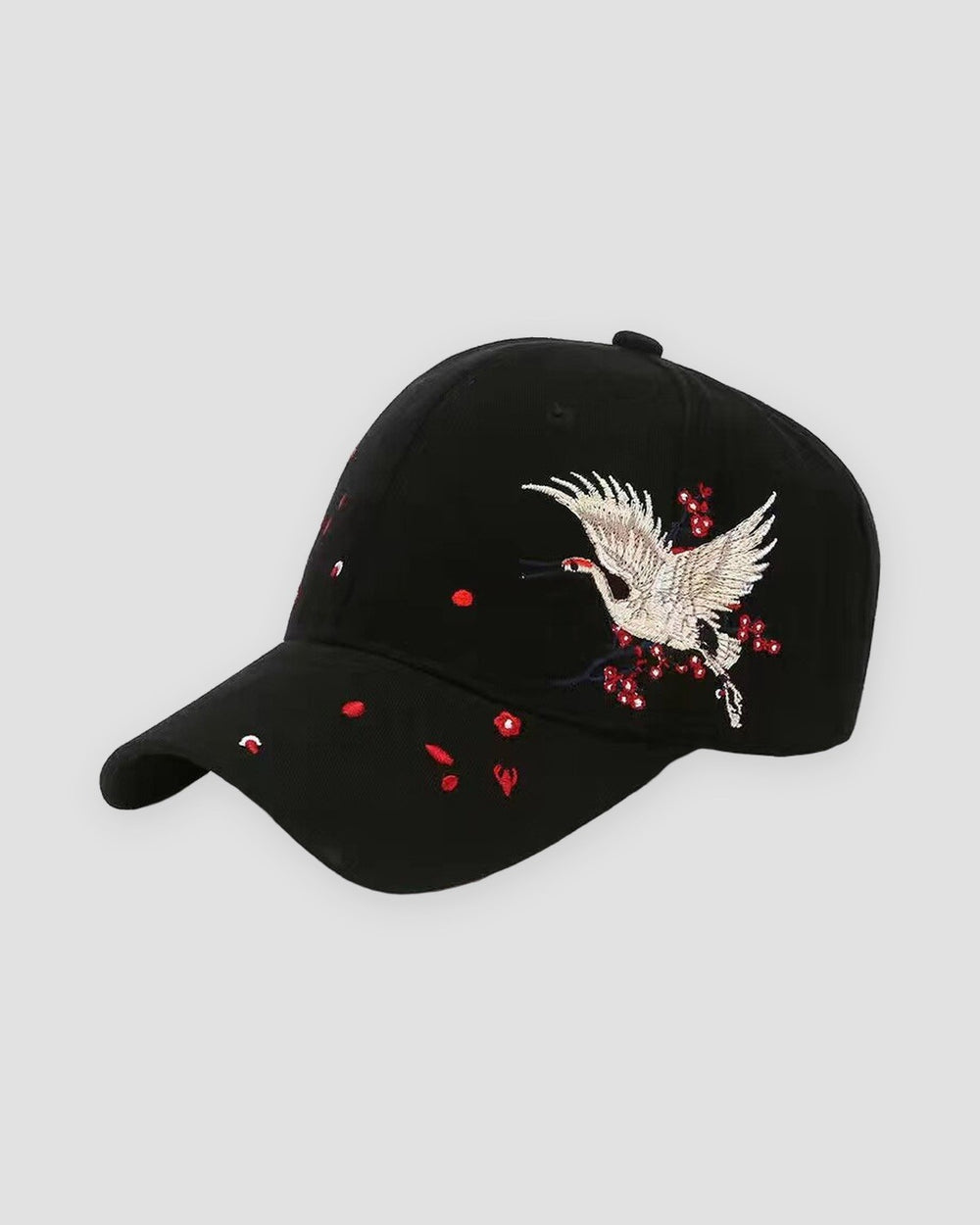 Black baseball cap with a cream and gold crane embroidered over red plum blossoms on the side of the crown