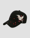 Black baseball cap with a cream and gold crane embroidered over red plum blossoms on the side of the crown