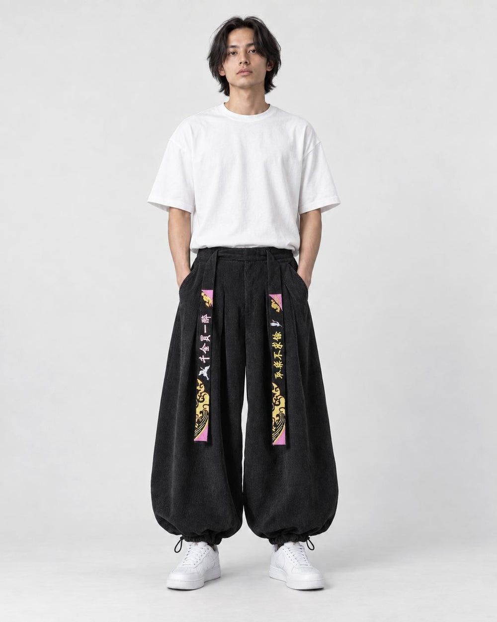 Model wearing the black crane embroidered corduroy pants, front view