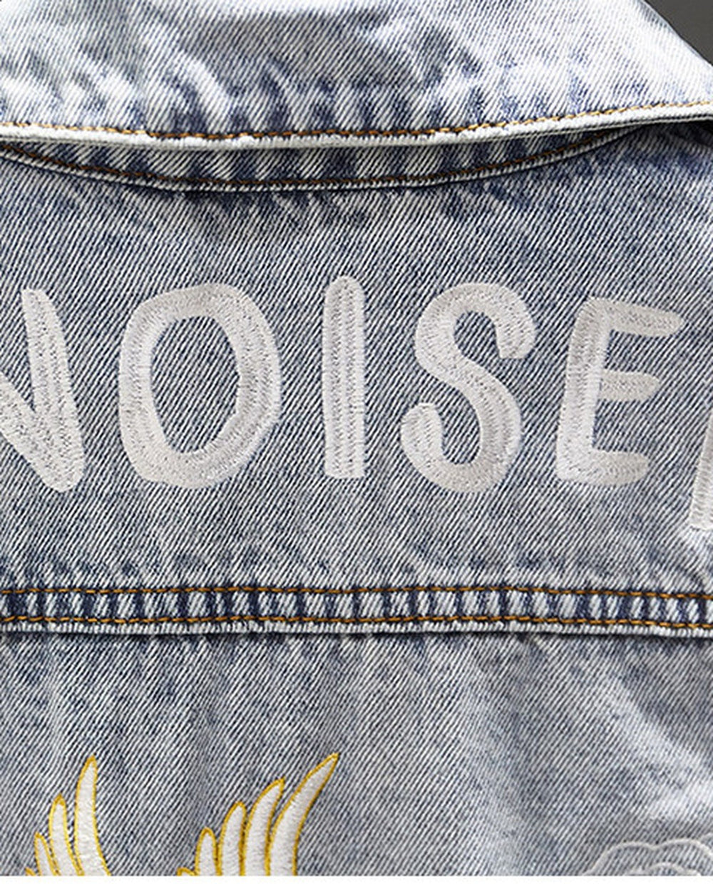 Close-up of the white CHINOISERIE lettering stitched across the shoulders