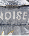 Close-up of the white CHINOISERIE lettering stitched across the shoulders