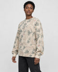 Model wearing the apricot crane print knit sweater with black jeans, three-quarter view