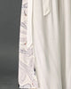 Close-up of the pale gray crane and wave side panel and the tie sash on the white wide-leg pants