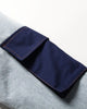 Close-up of the navy flap pocket on the light blue denim sleeve