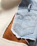Close-up of the raw-edged denim pocket over the tan suede-look panel