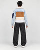 Model wearing the light blue cropped jacket, back view of the tan panel and fleece hem