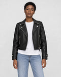 Model wearing the black cropped moto jacket open over a white tee, front view