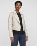 Model wearing the cream cropped moto jacket open over a black tee, three-quarter view