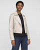 Model wearing the cream cropped moto jacket open over a black tee, three-quarter view
