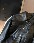 Close-up of the flap pockets and gold snaps on the black jacket