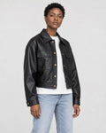 Model wearing the black cropped PU leather jacket with a white tee, three-quarter view