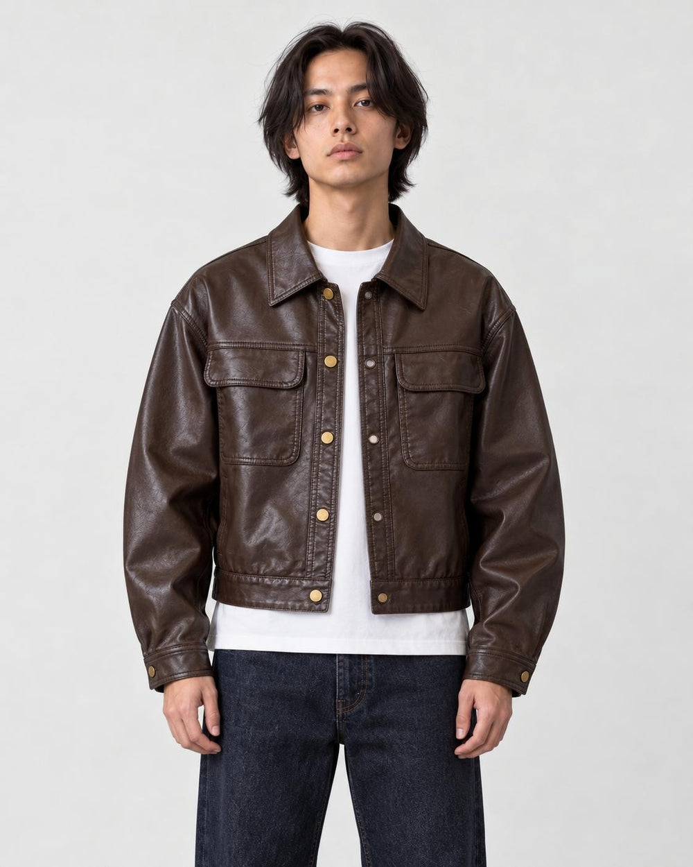 Model wearing the deep brown cropped PU leather jacket with a white tee, front view