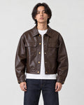 Model wearing the deep brown cropped PU leather jacket with a white tee, front view