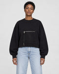 Model wearing the black cropped sweatshirt with light-wash jeans, front view