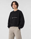 Model wearing the cropped zip pocket sweatshirt with stone trousers, three-quarter view