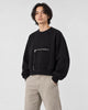 Model wearing the cropped zip pocket sweatshirt with stone trousers, three-quarter view