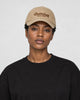 Model wearing the khaki cursive script dad cap with a black tee, side view