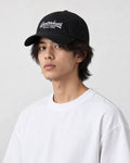Model wearing the black cursive script dad cap with a white tee, three-quarter view