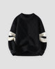 Black diamond cable knit sweater with cream sleeve stripes