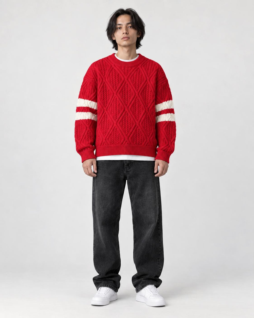 Model wearing the red cable knit sweater with jeans, front view