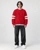 Model wearing the red cable knit sweater with jeans, front view