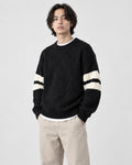 Model wearing the black cable knit sweater, three-quarter view