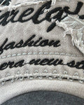 Close-up of the embroidered script lettering on the frayed patch