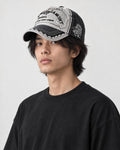 Model wearing the black distressed patch cap, three-quarter view